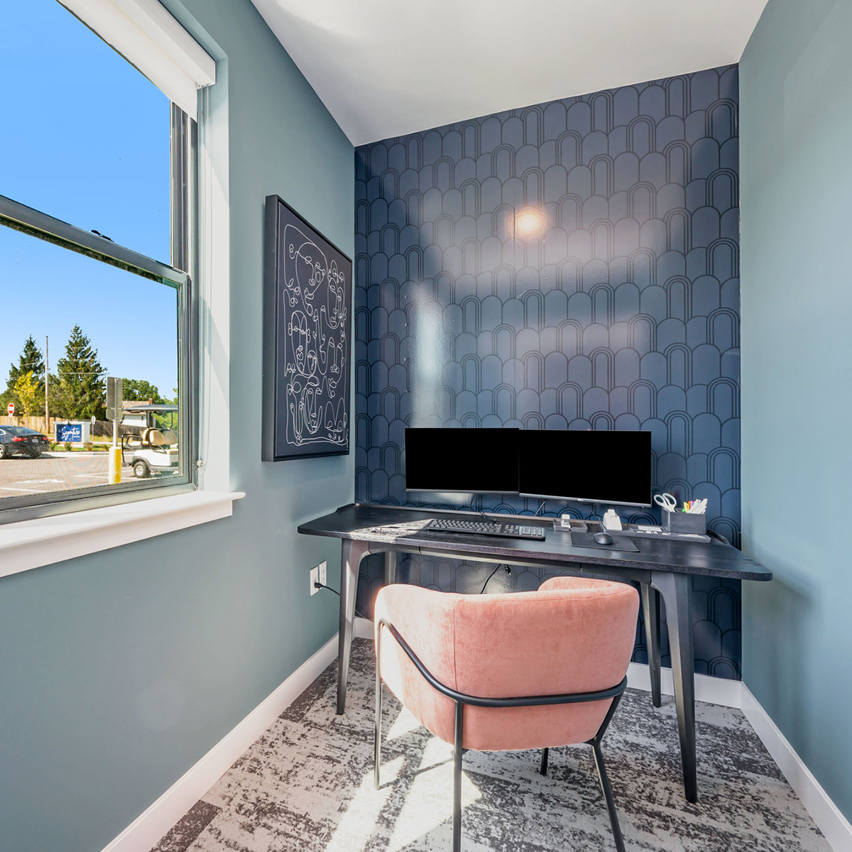 Focus room designed with robin's egg blue walls, a pink velvet chair, and navy wallpaper.